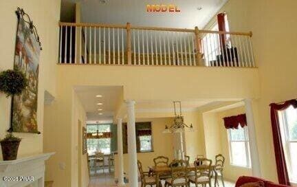 dining space featuring a towering ceiling and decorative columns