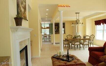 living room with decorative columns and a notable chandelier