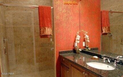 bathroom with vanity and tiled shower