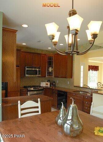 kitchen with appliances with stainless steel finishes, sink, and decorative backsplash