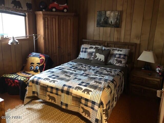 bedroom featuring wood walls