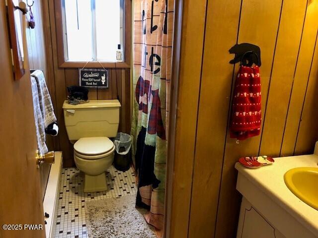 bathroom featuring tile patterned flooring, vanity, curtained shower, and toilet