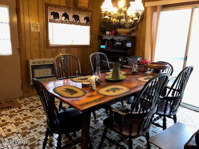 dining room featuring wooden walls and an inviting chandelier