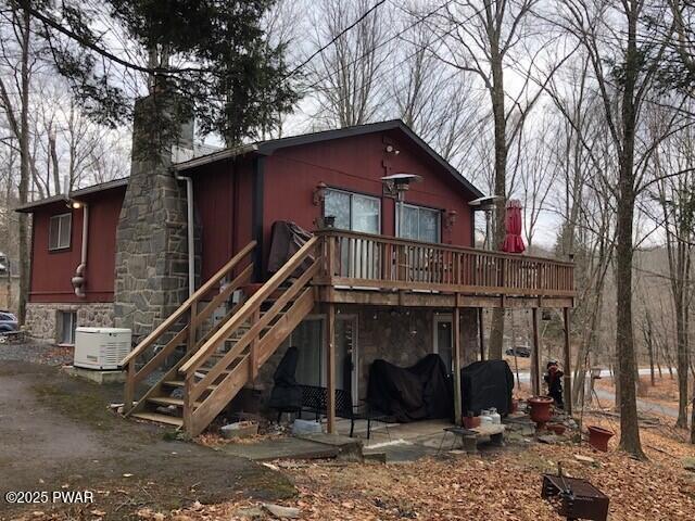 rear view of property with a deck and cooling unit