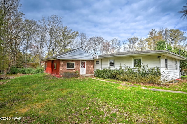 ranch-style home featuring brick siding and a front yard