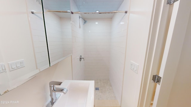 bathroom with sink and tiled shower