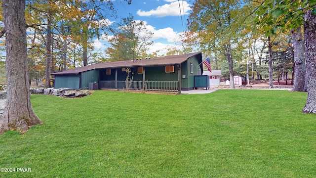 back of property featuring central AC unit and a yard