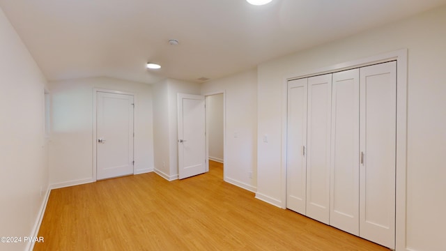 unfurnished bedroom with a closet and light wood-type flooring