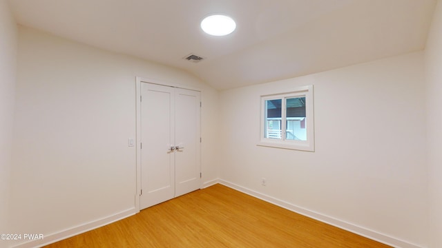 interior space featuring lofted ceiling and hardwood / wood-style flooring