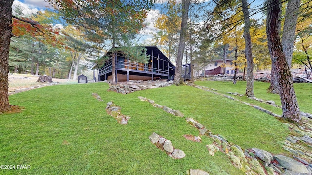 view of yard featuring a wooden deck and a sunroom