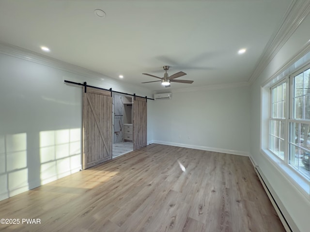 interior space featuring baseboard heating, light hardwood / wood-style flooring, a wall unit AC, ceiling fan, and a barn door