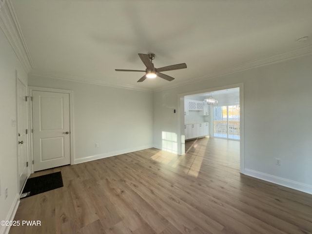 unfurnished living room featuring ceiling fan with notable chandelier, light hardwood / wood-style flooring, and crown molding