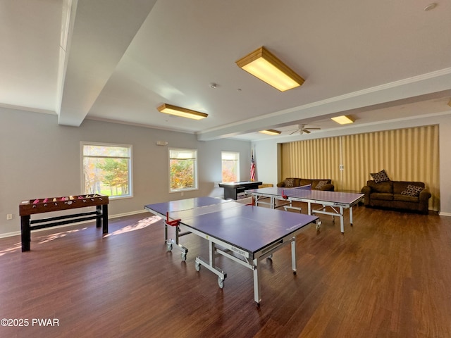 game room with ceiling fan, hardwood / wood-style floors, crown molding, and beam ceiling