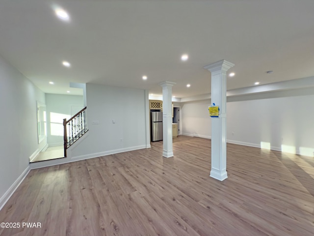 basement with stainless steel fridge and light wood-type flooring