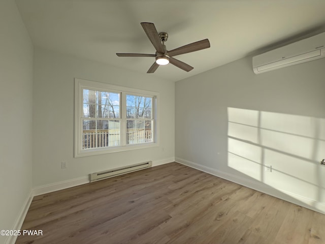 spare room featuring a wall mounted air conditioner, ceiling fan, a baseboard heating unit, and hardwood / wood-style floors