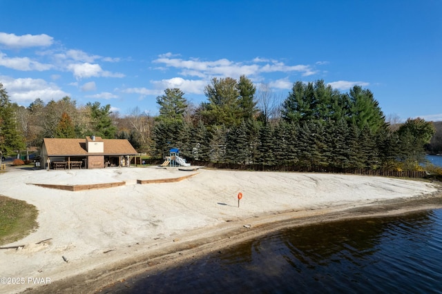 exterior space with a playground and a water view