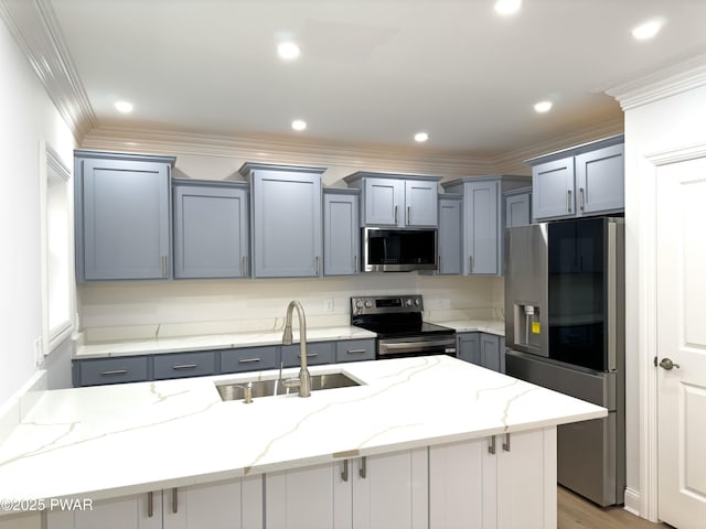 kitchen featuring sink, light stone counters, a kitchen island with sink, and appliances with stainless steel finishes