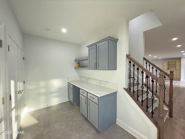 kitchen featuring gray cabinetry and light stone counters