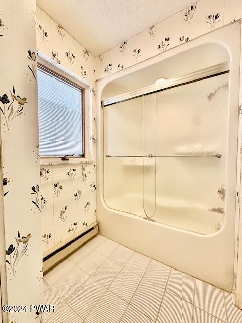 bathroom featuring a textured ceiling and a baseboard heating unit