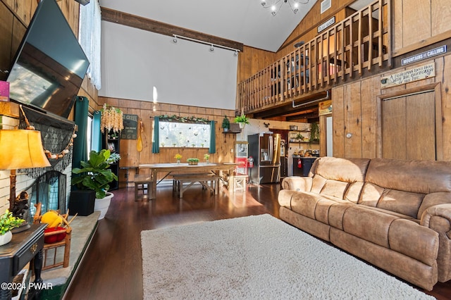 living room with wood walls, dark hardwood / wood-style flooring, and high vaulted ceiling