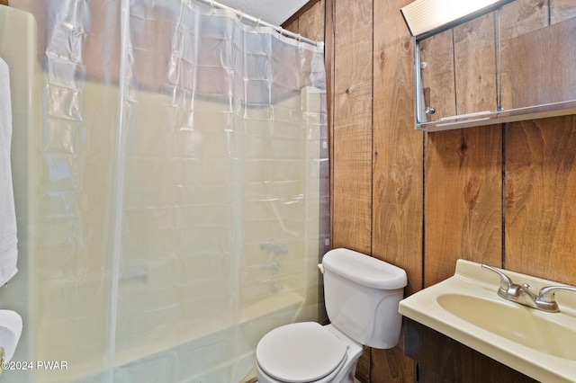 bathroom with vanity, wood walls, toilet, and a textured ceiling