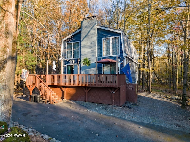 rear view of house featuring a wooden deck