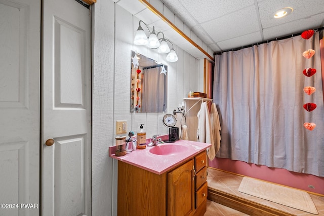 bathroom with a drop ceiling, vanity, and shower / bath combo