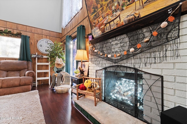 living room featuring wooden walls, a fireplace, and dark hardwood / wood-style floors