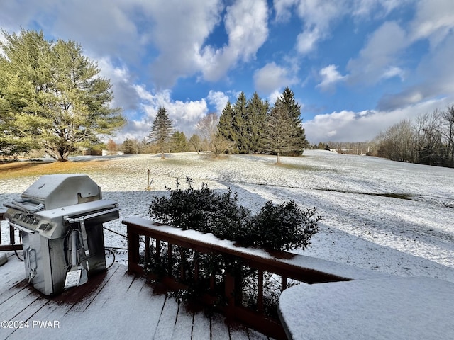 snow covered deck with a grill