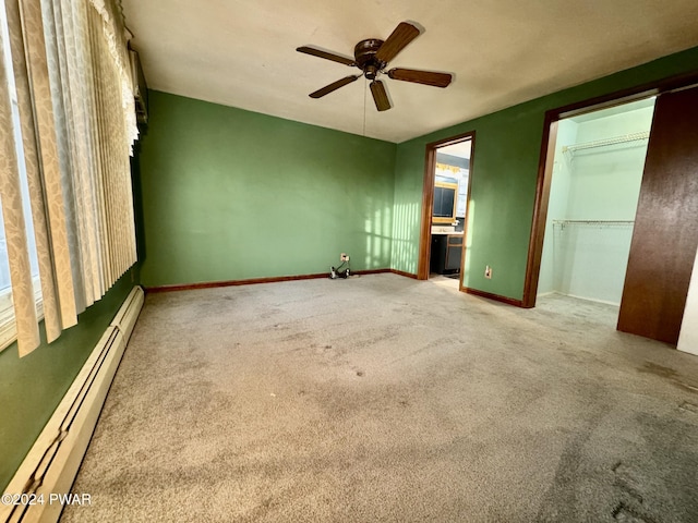 unfurnished bedroom featuring carpet floors, a closet, a baseboard heating unit, and ceiling fan