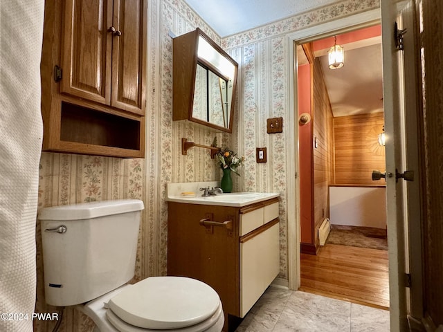 bathroom with vanity, toilet, and baseboard heating