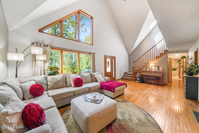 living room featuring high vaulted ceiling and wood-type flooring