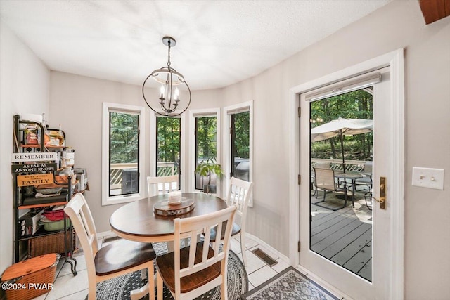 dining space featuring a chandelier, light tile patterned floors, and a textured ceiling