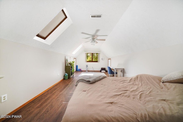 unfurnished bedroom with vaulted ceiling with skylight, dark hardwood / wood-style floors, ceiling fan, and a textured ceiling