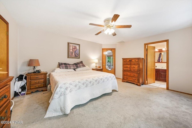 carpeted bedroom featuring ceiling fan and ensuite bath