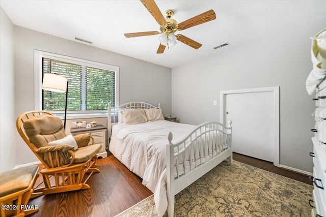 bedroom with dark hardwood / wood-style flooring and ceiling fan