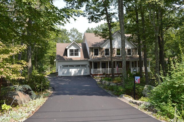 colonial inspired home featuring a porch and a garage