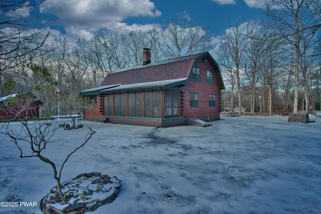 view of snowy exterior with a sunroom