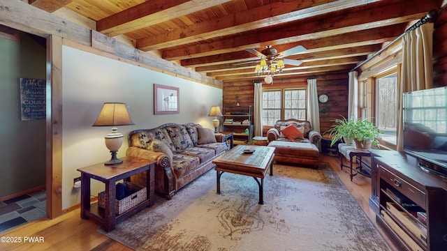 living room featuring hardwood / wood-style floors, rustic walls, ceiling fan, wood ceiling, and beam ceiling