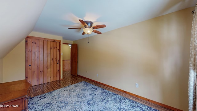 unfurnished bedroom with hardwood / wood-style flooring, ceiling fan, and vaulted ceiling