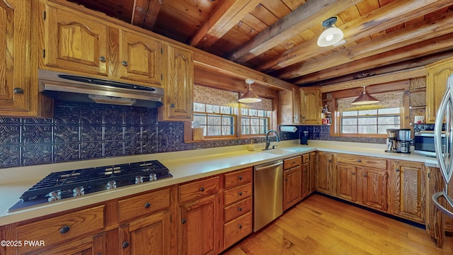 kitchen featuring pendant lighting, stainless steel appliances, sink, and backsplash