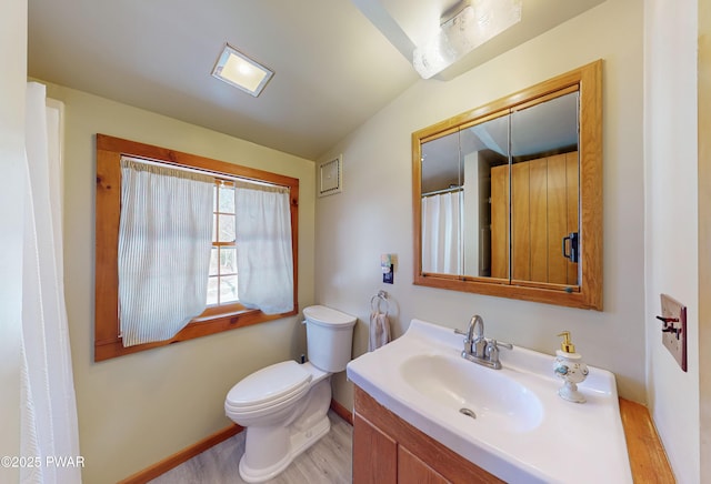 bathroom featuring vanity, vaulted ceiling, and toilet