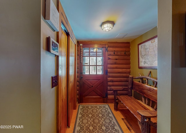 doorway to outside featuring hardwood / wood-style floors and log walls