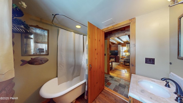 bathroom with hardwood / wood-style flooring, vanity, and shower / bathtub combination with curtain