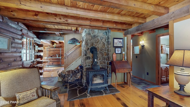 living room with wood ceiling, rustic walls, beam ceiling, wood-type flooring, and a wood stove