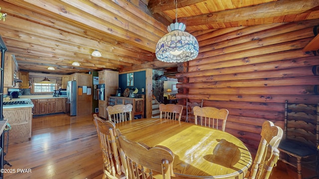 dining space with beamed ceiling, wooden ceiling, rustic walls, and light wood-type flooring