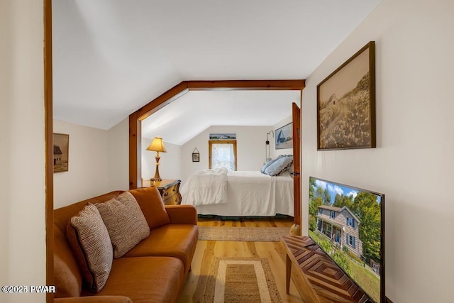 bedroom with vaulted ceiling and hardwood / wood-style floors