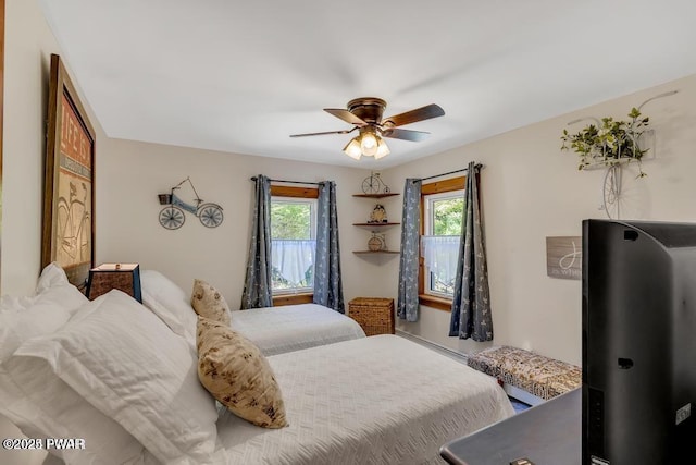 bedroom featuring a baseboard heating unit and ceiling fan