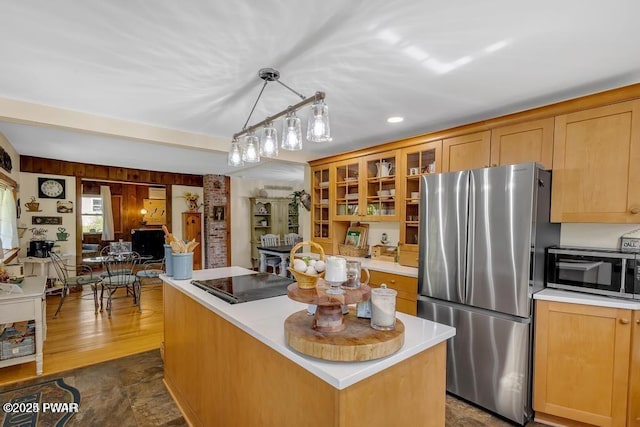 kitchen featuring pendant lighting, stainless steel appliances, wooden walls, and a center island