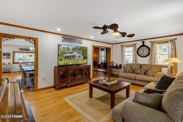 living room with ornamental molding, ceiling fan, light wood-type flooring, and baseboard heating